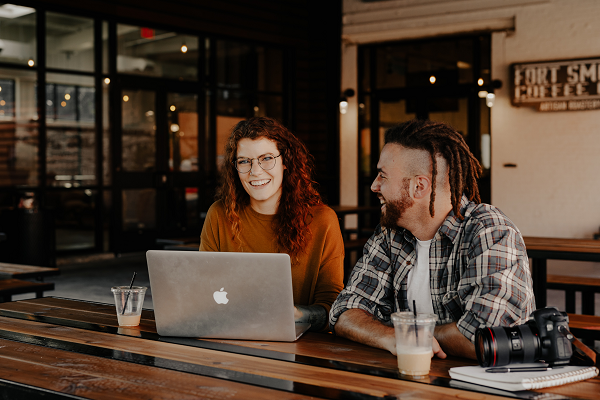 Woman-and-a-man-seated-in-a-coffee-shop-with-a-laptop-and-digital-camerav2