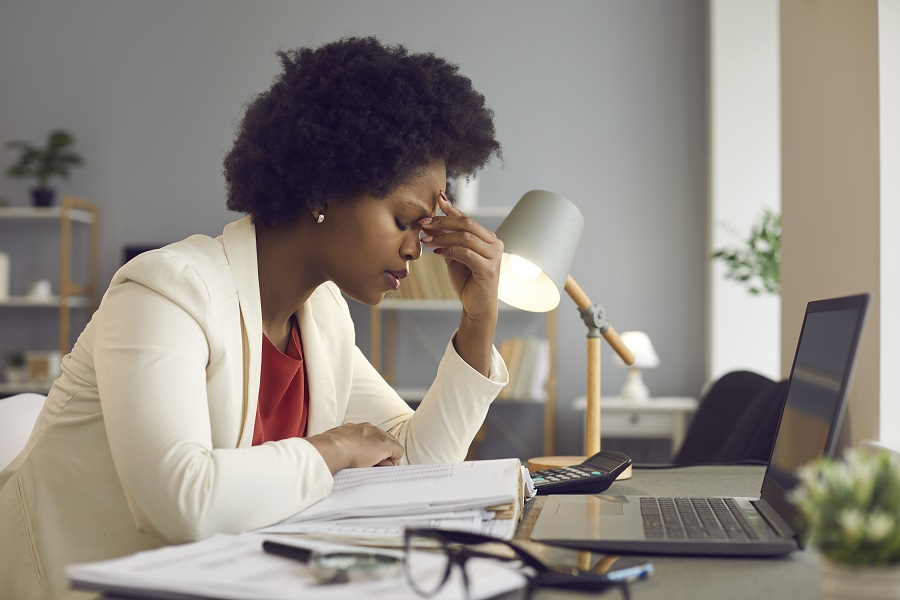 A woman at her desk working on a laptop